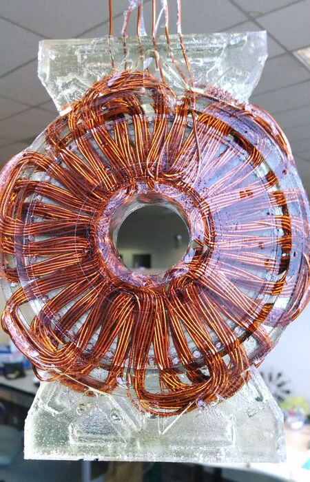 Copper and epoxy stator is sandwiched between two magnet array plates in motor.