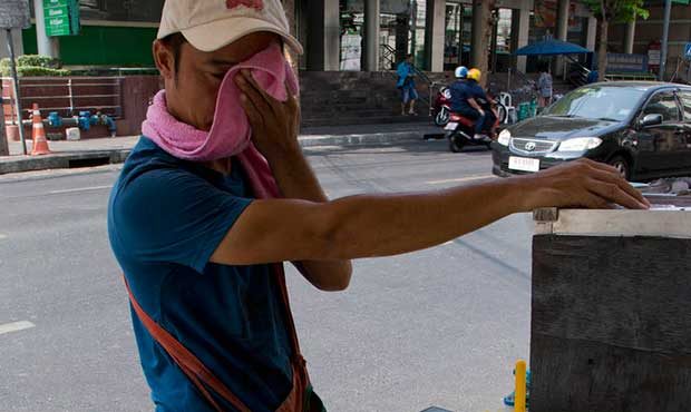 photo of man wiping sweat from his face