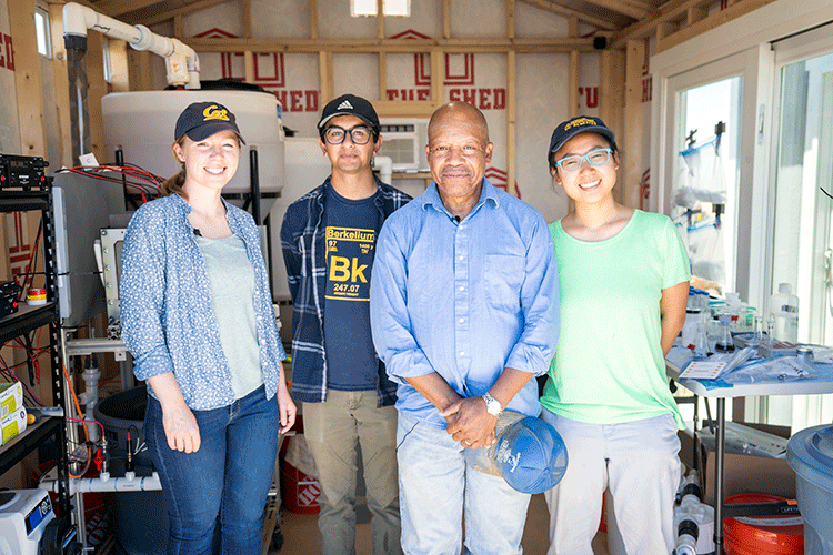 Logan Smesrud (left), Jay Majmudar, the Rev. Dennis Hutson, and Eleanor Chin (right) with the arsenic treatment system on Hutson’s farm. (Credit: Ashok Gadgil)