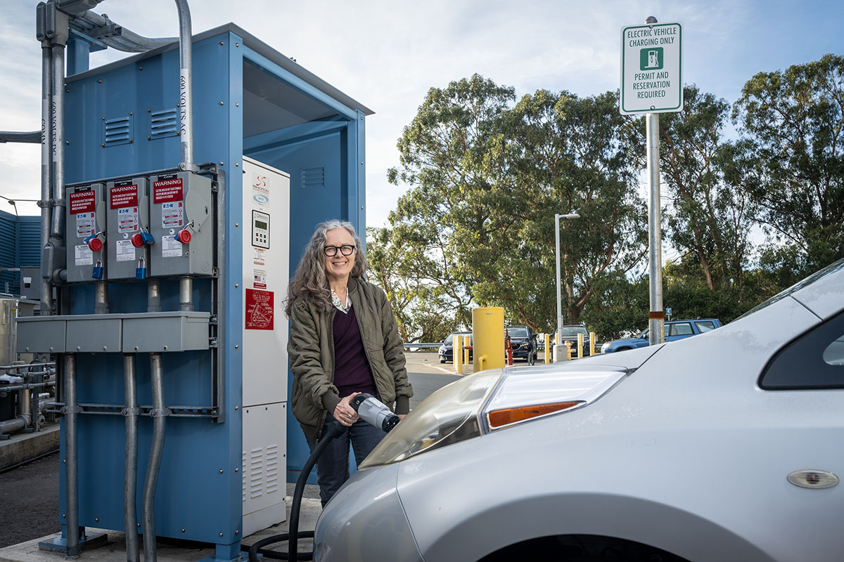  Cindy Regnier at FLEXLAB's bidirectional EV charging station. (Credit: Thor Swift/Berkeley Lab)